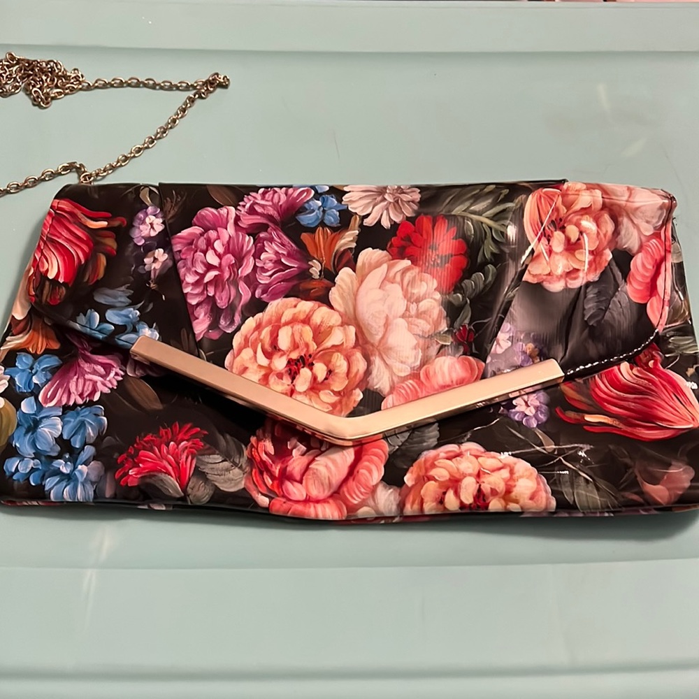 Katie & Kelly black and floral multicolor design. Gold chained shoulder strap.